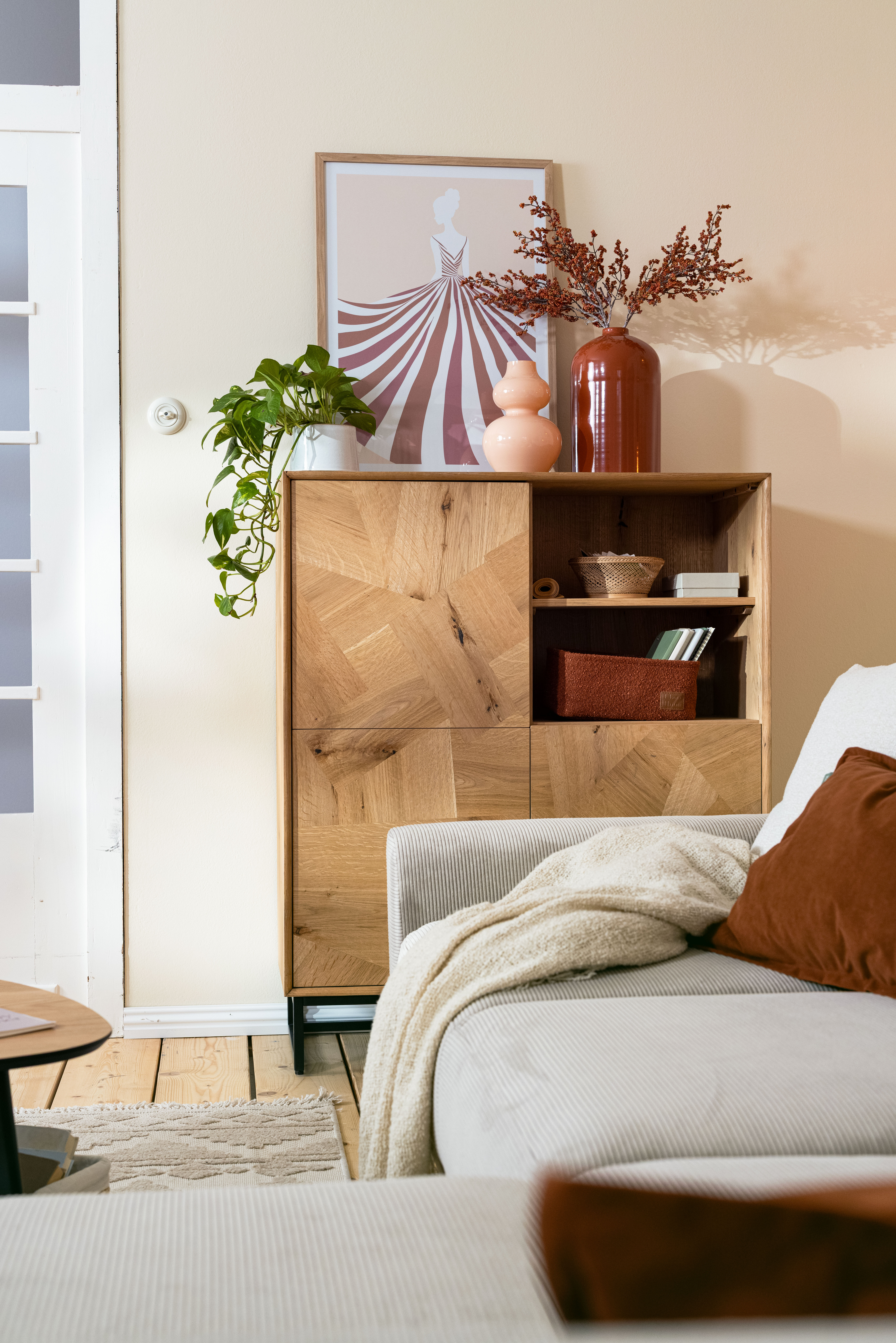 Helles Wohnzimmer mit grauem Ecksofa, Hocker und Teppich
