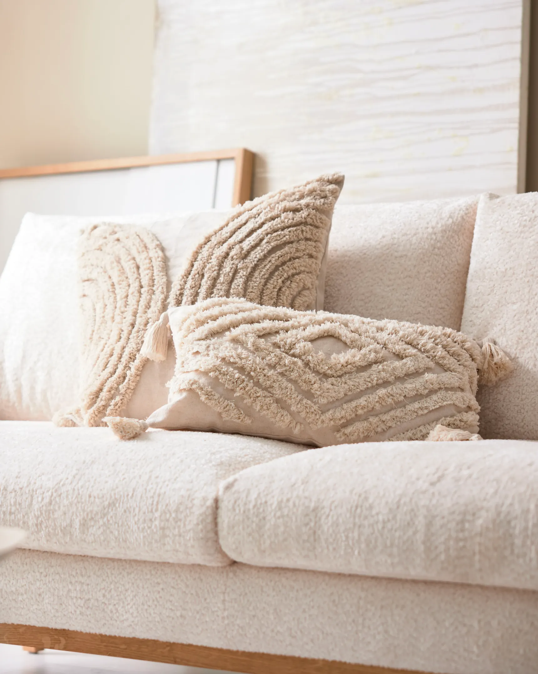 Cremefarbene Strickkissen auf einem hellen Sofa